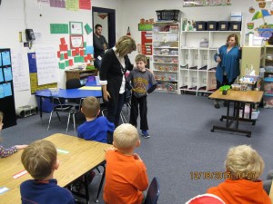 Eli telling the class how he did chores to earn money for Komeka.
